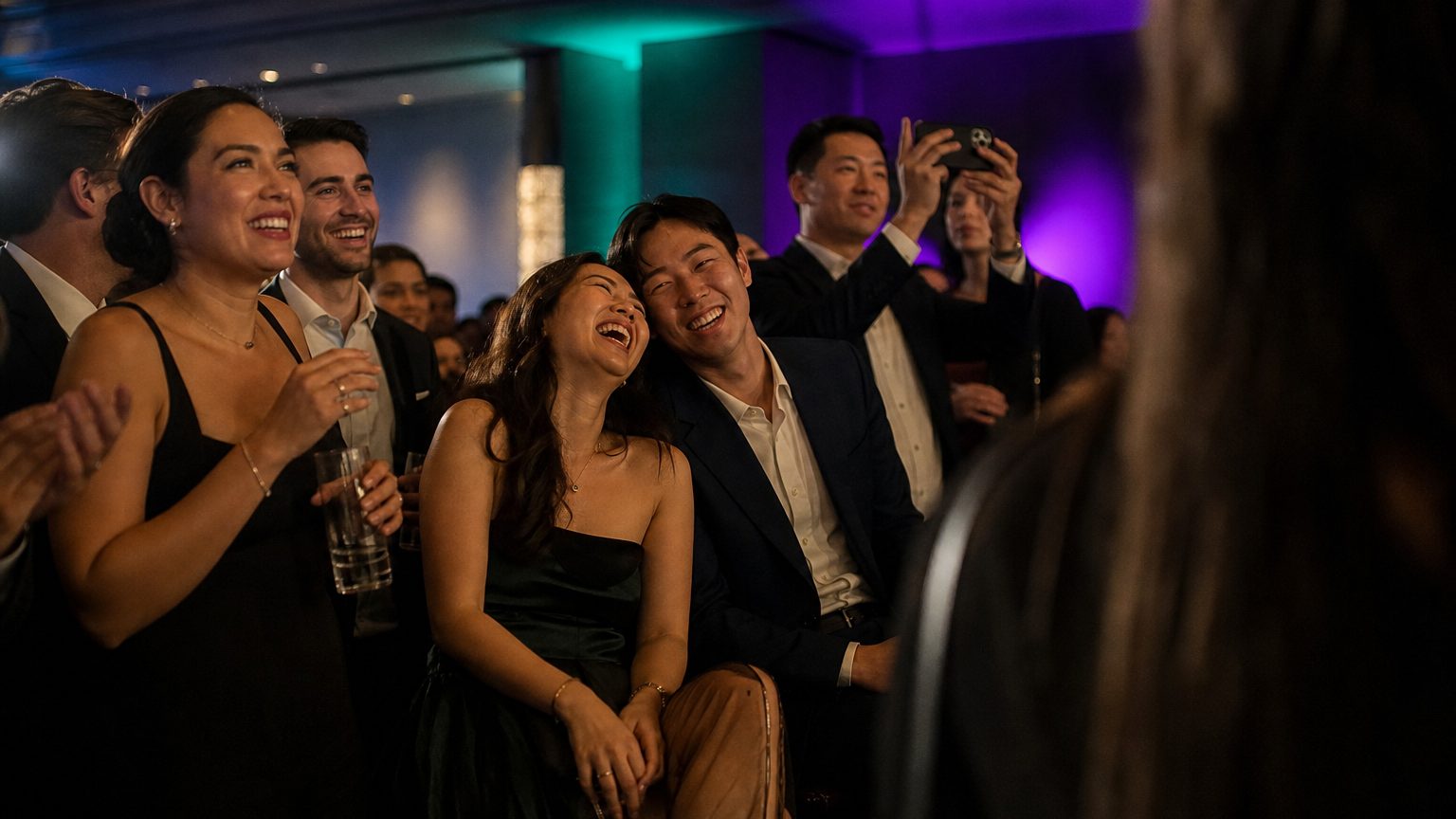 Attendees watching and clapping near a small stage