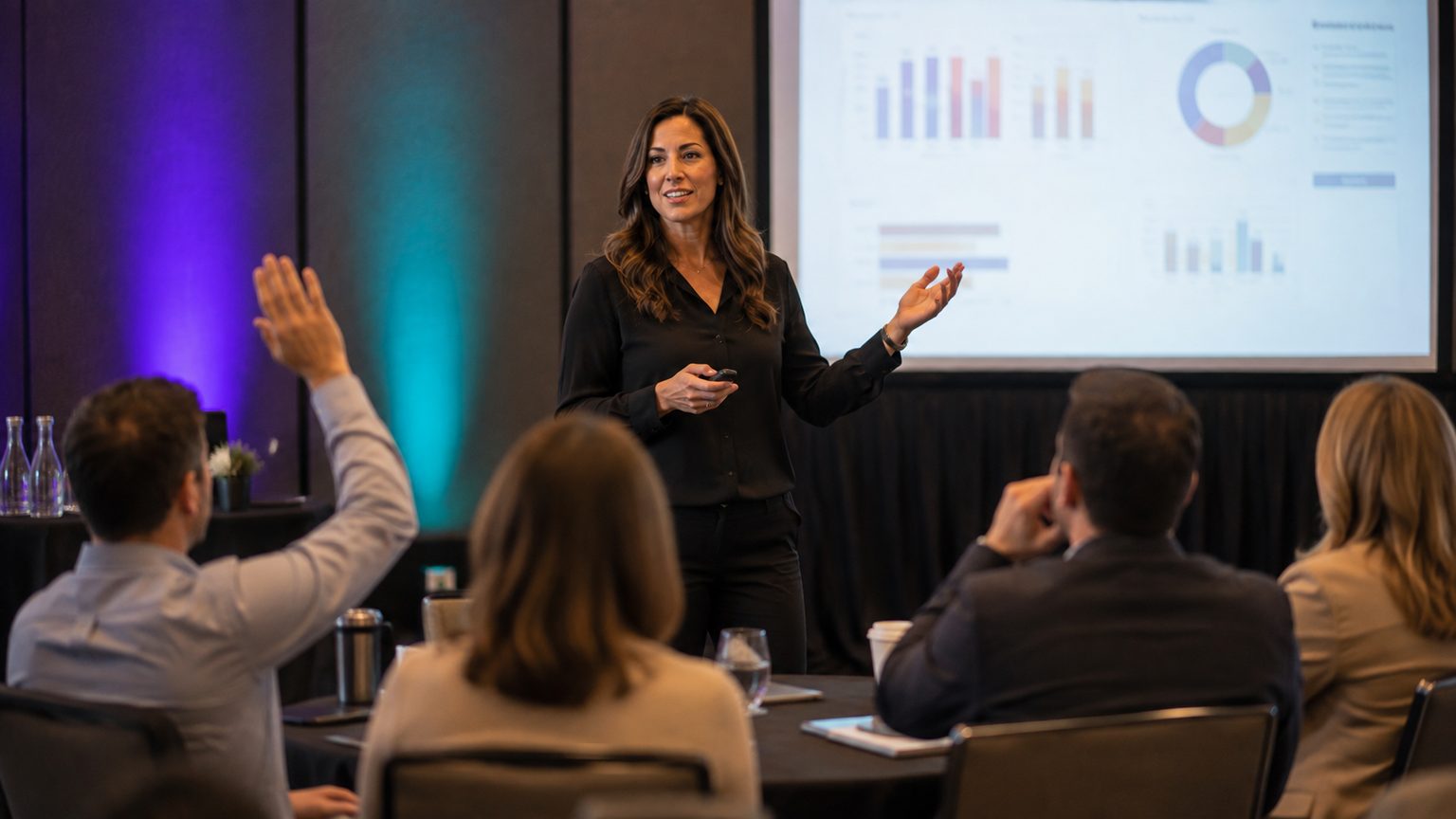 A sales leader presenting kickoff results to her team in a hotel meeting room