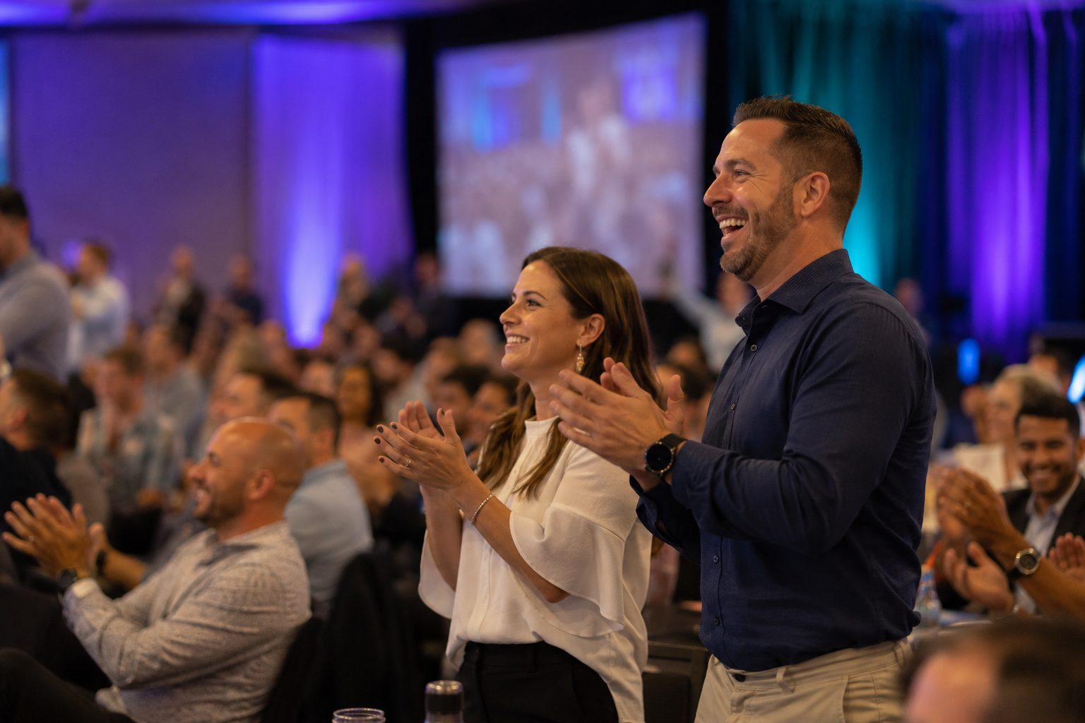 Sales team on their feet applauding during a kickoff general session