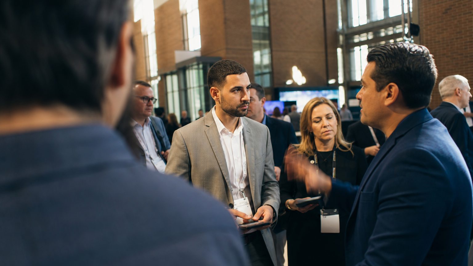 Two corporate event planners across a hotel meeting-room table mid-discussion