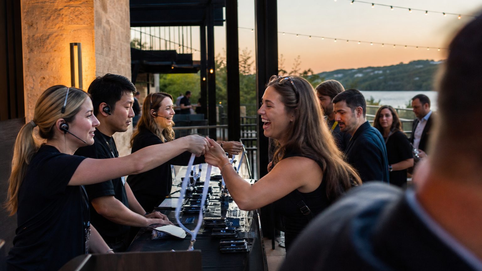 Attendees collecting badges from staff at a conference registration desk