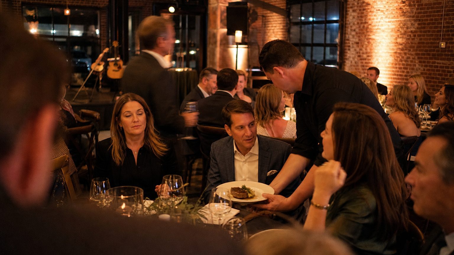 A venue manager gesturing across a function space to two corporate planners