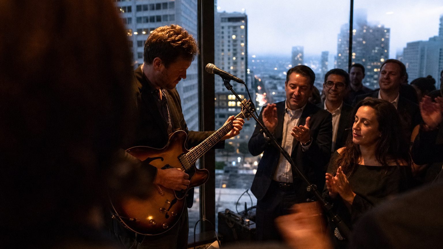 A venue manager gesturing across a function space to two corporate planners