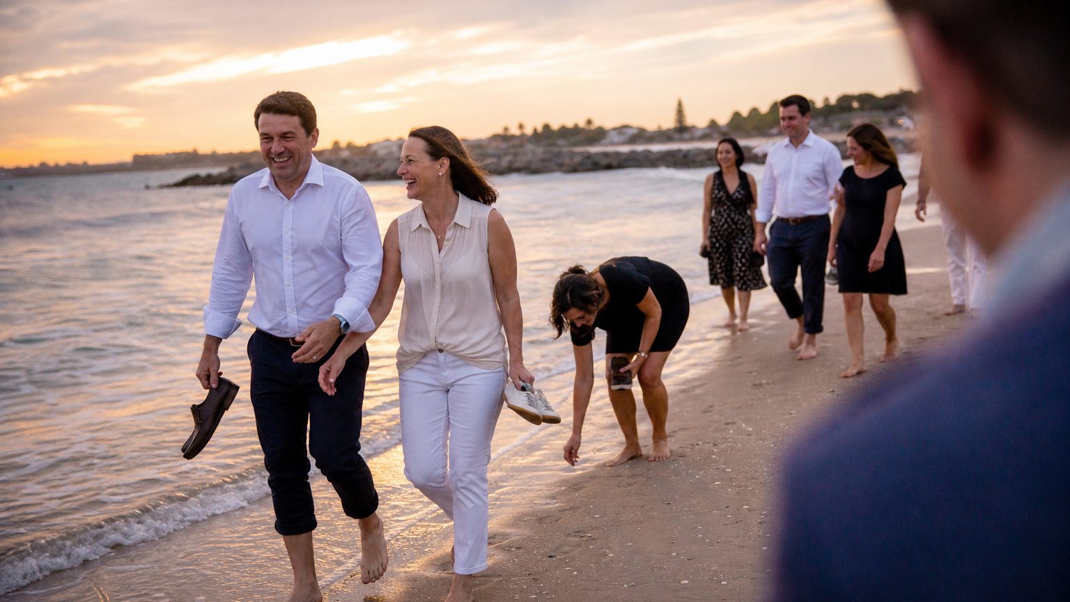 Incentive trip guests walking a beach at sunset
