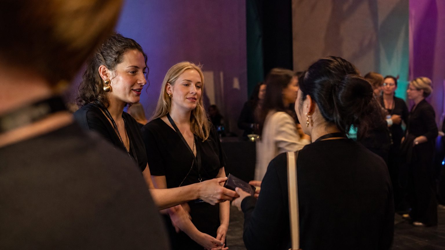 Two brand staff in conversation with attendees at a stand