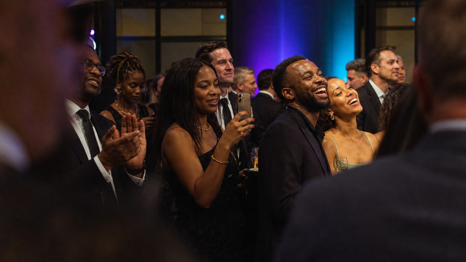 Attendees watching and clapping near a small stage