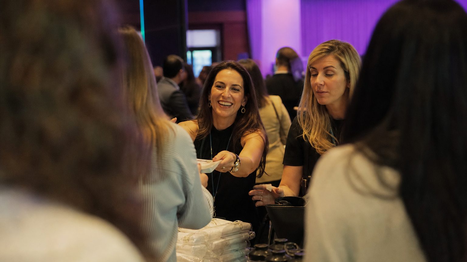 Two brand staff in conversation with attendees at a stand