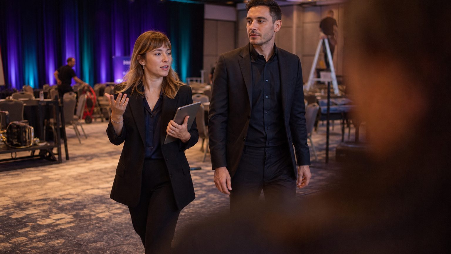 Two corporate event planners walking a venue together mid-conversation