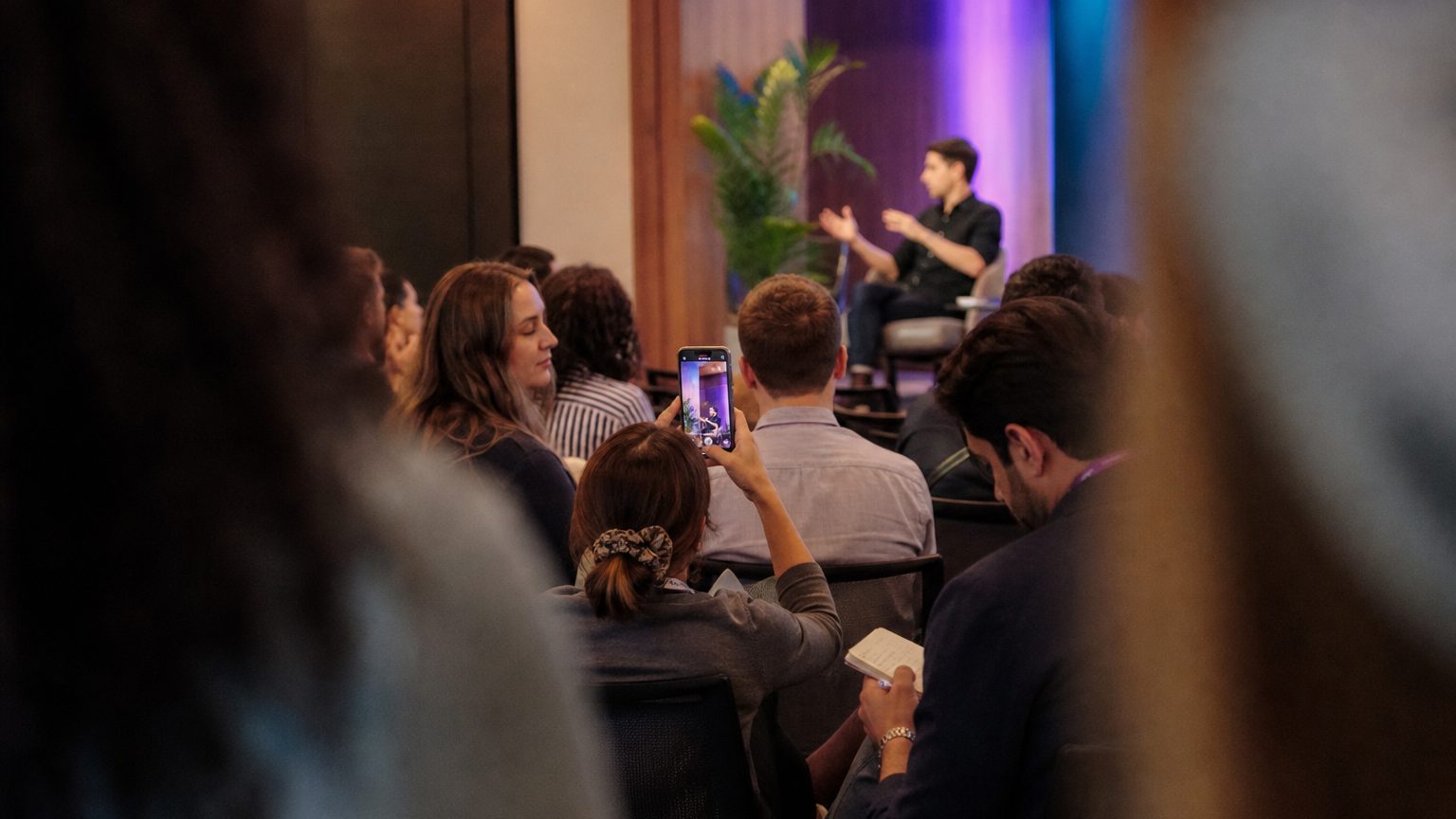 A speaker mid-gesture on a low stage