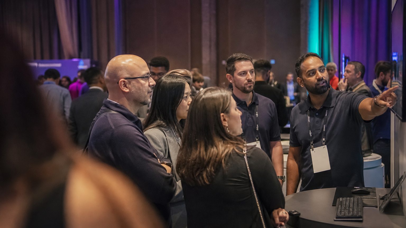 Exhibit staff talking with attendees at a busy stand