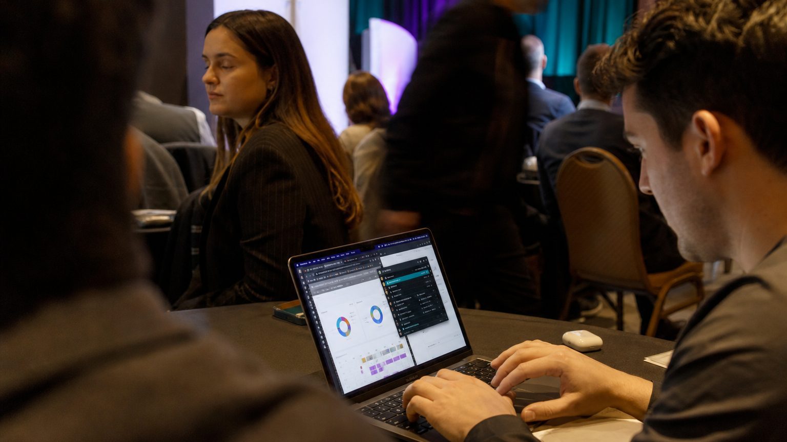 Close-up of a professional’s hands typing on a sleek laptop keyboard, with multiple tabs open showing event management